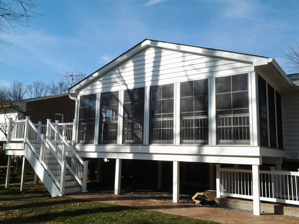 This is an image from Nevins Construction of an Eze Breeze room and a white composite deck with white rails and balusters.  All front facing joists have veen wrapped with composite material.  All posts have been wrapped in composite.